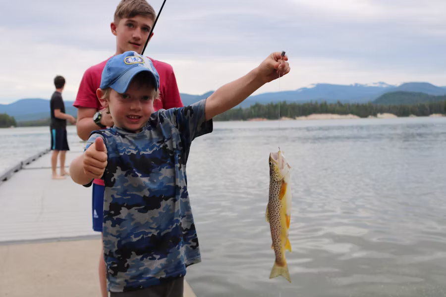 A young angler reeling in a fish from a boat in Rhode Island waters